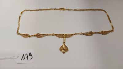 gros plan d'un collier en or sur fond blanc