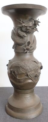 un vase orné d'un dragon, posé sur une table