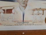 a painting of a man holding a tennis racquet on a wall