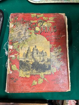 un vieux livre posé sur une table à côté d'un téléphone portable