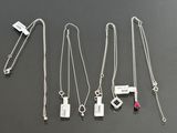 six different necklaces with different designs on a black surface