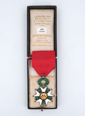 an old medal with a red ribbon and a star on it