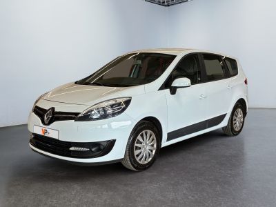 La voiture blanche est garée dans une grande pièce équipée d'un ventilateur de plafond.