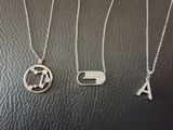 three silver necklaces with the letter a, a, and a