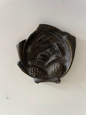 a bronze sculpture of a bird on a white surface