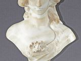 marble bust of a woman with a flowered head on a pedestal