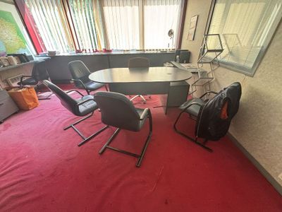 plusieurs chaises et une table dans une pièce recouverte d'un tapis rouge