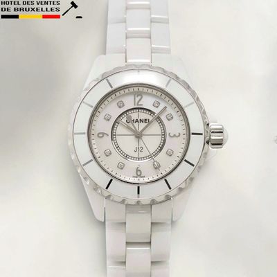 the watch is white and has a diamond bezeled dial