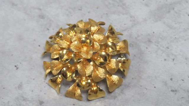 Broche ronde à décor de feuillage en or 18 carats 750 millièmes. ...
