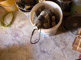 a bucket of tools on the floor next to a bucket of paint