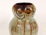 a small vase with a brown and white design on it