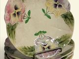 quatre assiettes empilées les unes sur les autres, ornées de pensées peintes