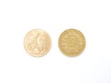 deux pièces d'or posées sur une surface blanche, sur fond blanc