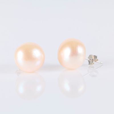 pair of pink pearl earrings on white background with reflection
