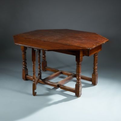 une petite table avec un plateau en bois sur fond gris