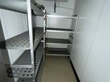 a small room with shelves and a fan in it