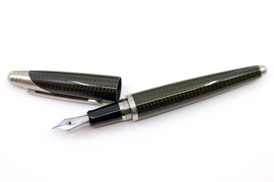 deux stylos à plume posés l'un sur l'autre sur une surface blanche