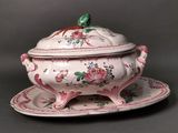 a white and pink tureeny dish with a bird on it