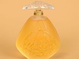 flacon de parfum en verre jaune avec un bouchon transparent, sur fond jaune