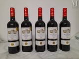 four bottles of wine are lined up on a table