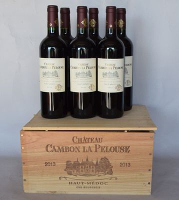 quatre bouteilles de vin se trouvent dans une caisse en bois posée sur une table
