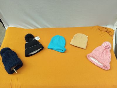 de nombreux bonnets et gants disposés sur un lit