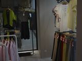 a picture of a clothing store with clothes hanging on racks