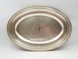 an antique silver plate on a white background with a small hole in the middle