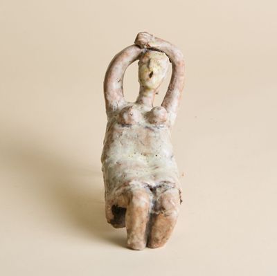 statue représentant une femme assise sur le dos, les mains derrière la tête