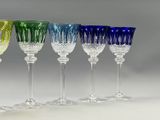 several different colored wine glasses are lined up in a row