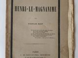 un vieux livre posé sur une table à côté d'un mur blanc
