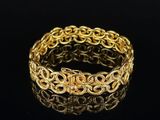 a close up of a gold bracelet on a black surface