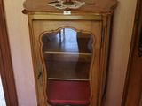 un petit meuble en bois surmonté d'un coussin rouge