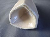 a white vase with a hole in it on a table