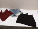two pairs of shorts and a sweater on a white table