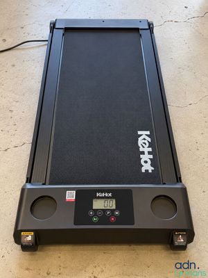 un tapis de course noir posé sur un parquet