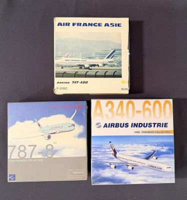 trois livres posés sur une table, avec un avion en arrière-plan
