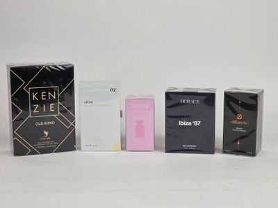 trois boîtes de parfum sont alignées sur une surface blanche