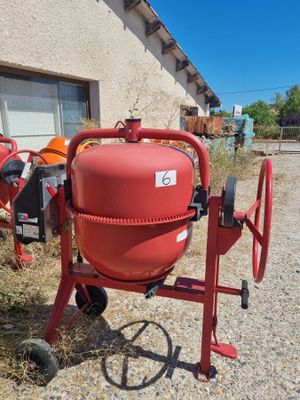 an image of a red cement mixer in front of a house