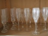 many empty wine glasses lined up on a shelf