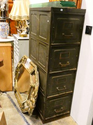 une grande commode surmontée d'un miroir, dans une pièce