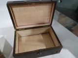 une petite boîte en bois ouverte, posée sur une table