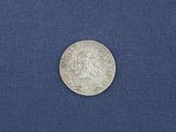 a close up of a silver coin on a blue cloth