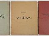 four books with handwriting on them are lined up in a row