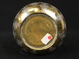 a gold vase with a red and white label on it