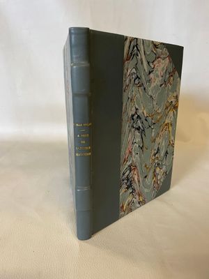 an old book sitting on top of a white cloth covered table