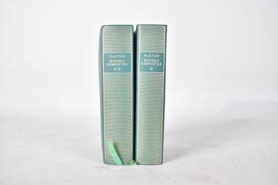 deux livres verts posés l'un sur l'autre sur une surface blanche