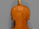 an old violin with a wooden back and bow on a gray background