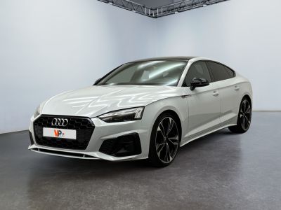 Une Audi RS4 blanche est garée dans une grande pièce