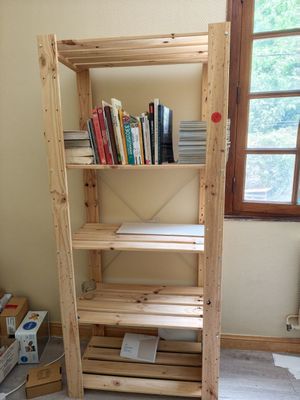 a wooden shelf with books on it in the corner of a room